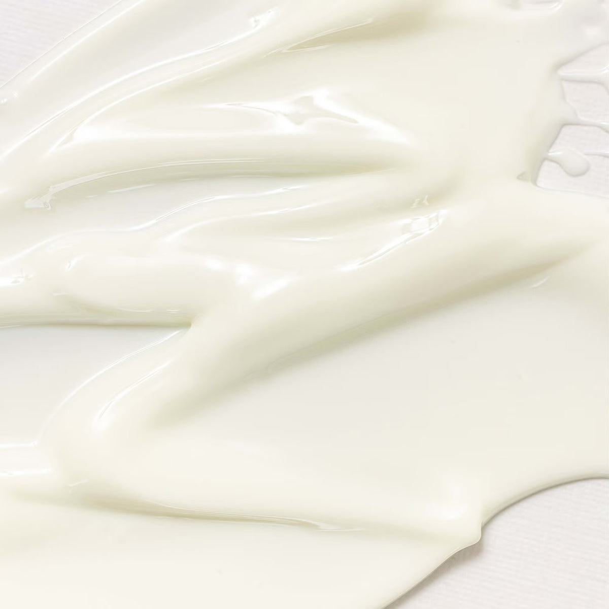 Close-up of the pale cream texture of Beauty of Joseon Relief Sun : Rice + Probiotics SPF50+ PA++++ spread across a light surface