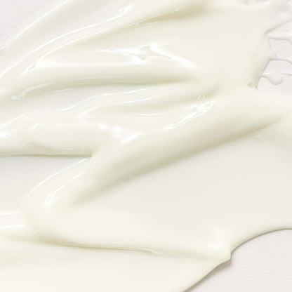 Close-up of the pale cream texture of Beauty of Joseon Relief Sun : Rice + Probiotics SPF50+ PA++++ spread across a light surface