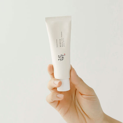Hand holding the full-size Beauty of Joseon Relief Sun : Rice + Probiotics SPF50+ PA++++ sunscreen tube against a plain background