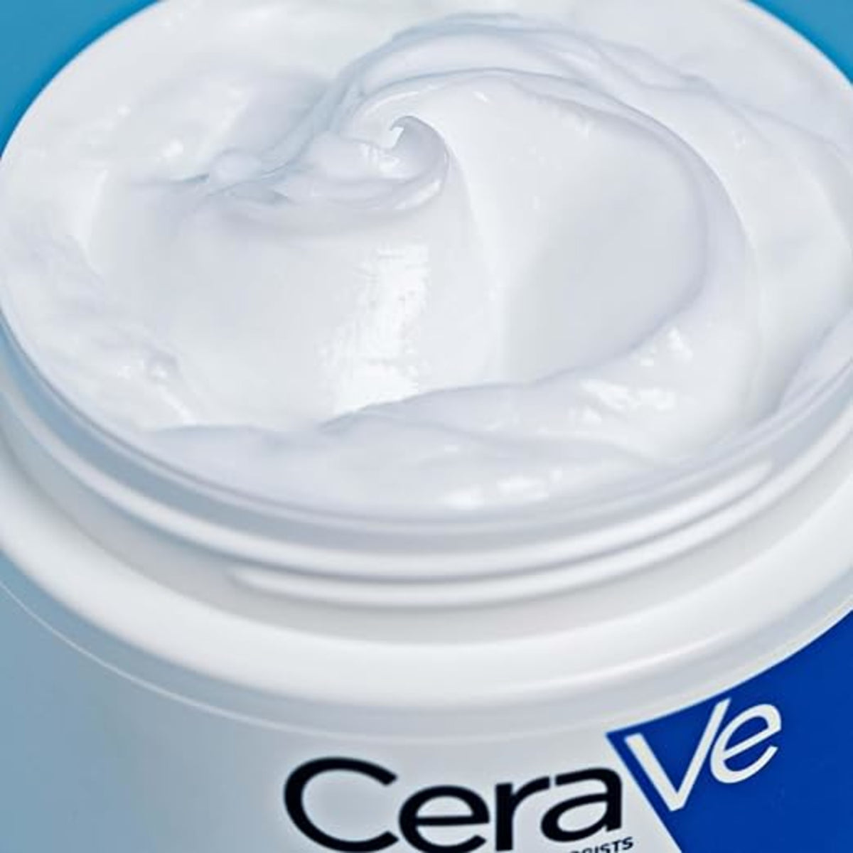 Close-up of the rich white cream texture inside an open CeraVe Moisturising Cream jar