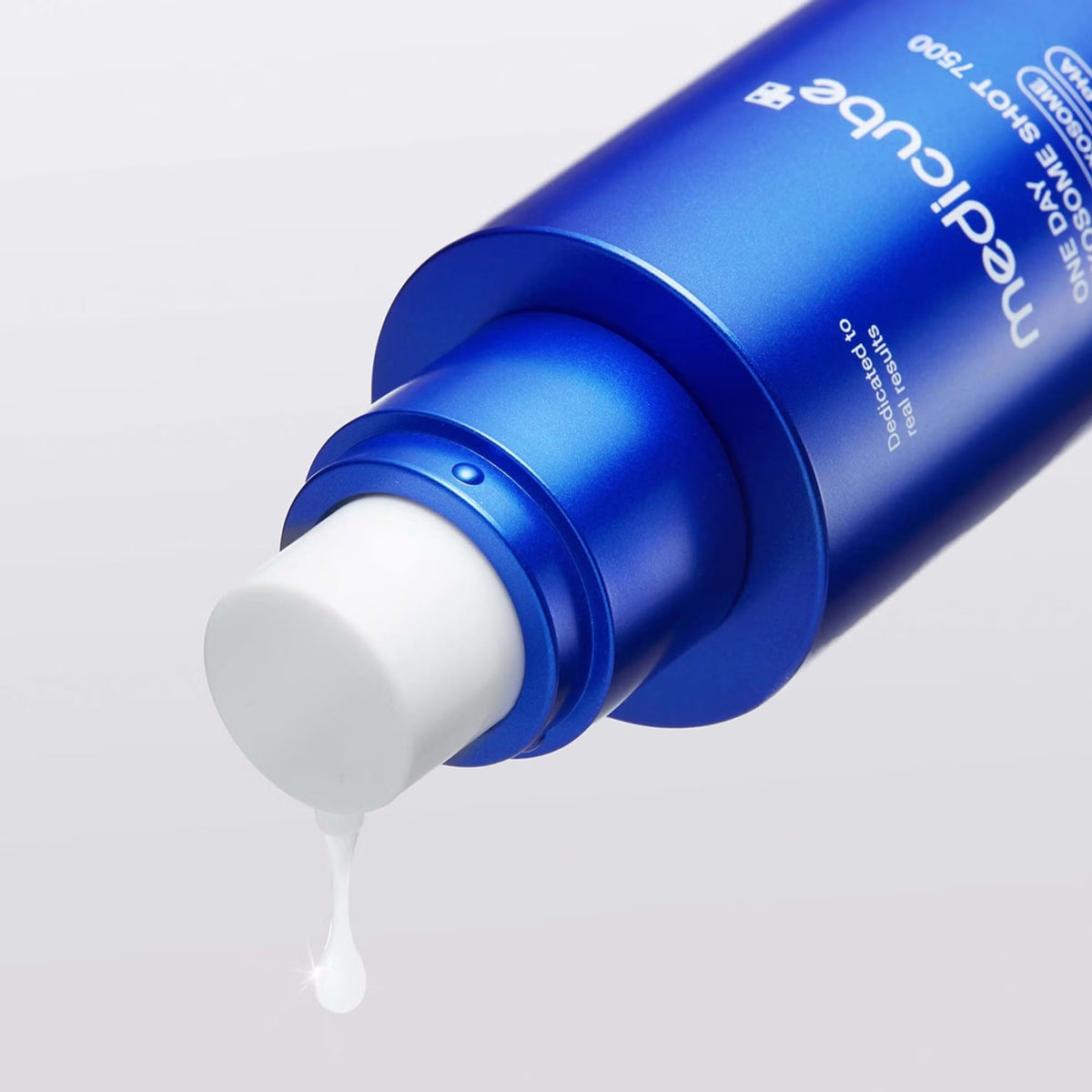 Close-up of white serum dispensing from the medicube One Day Exosome Shot 7500 pump bottle