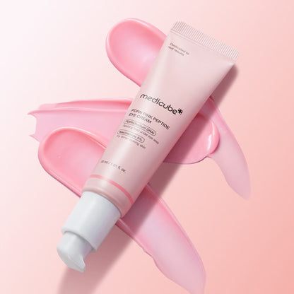 medicube PDRN Pink Peptide Eye Cream pink tube lying on pink background with pink cream swatches showing the cream texture